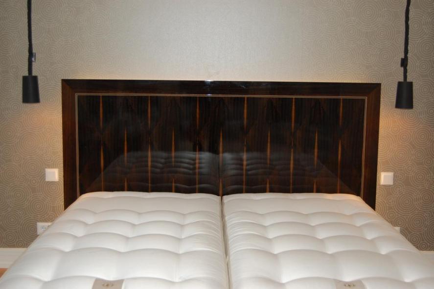 doppelbett-aus-holz-mit-dunklem-kopfteil