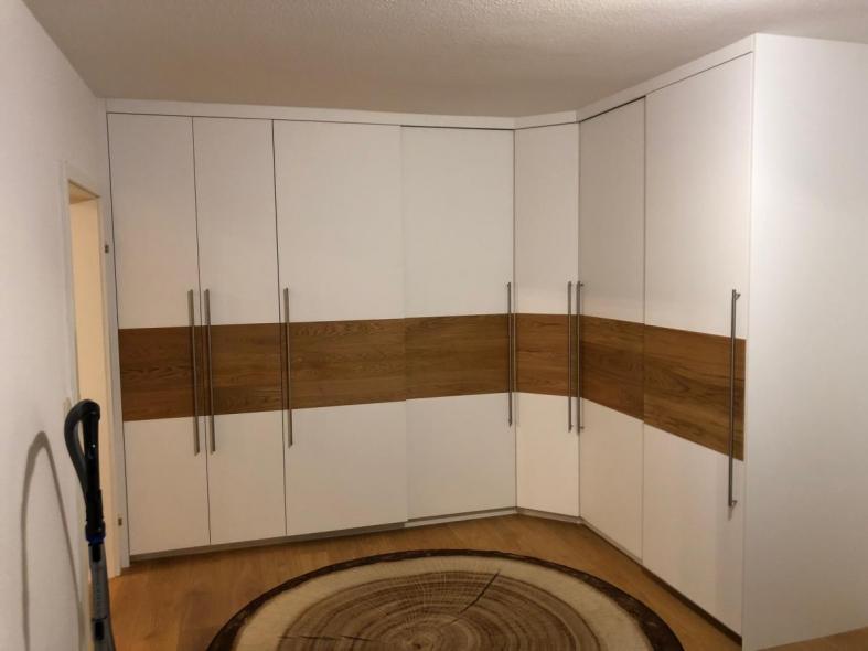 großer-eckkleiderschrank-in-weiß-mit-braunem-balken